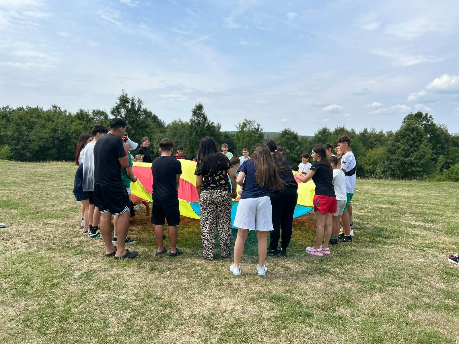 A parachute game on the grass during a volunteer visit
